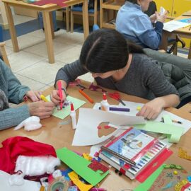 Alumnado de 4.º de ESO realizando postales navideñas con personas mayores en el Centro de Día de Covaresa