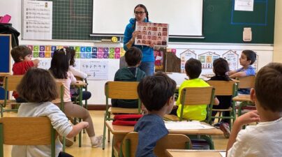 La dinamizadora muestra una lámina de rostros con distintos tonos de piel al alumnado de 1.º de Primaria.