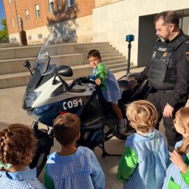 Un niño se sube a una moto de la Policía Nacional junto a un agente y sus compañeros de Infantil.