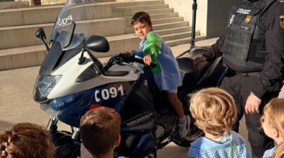 Un niño se sube a una moto de la Policía Nacional junto a un agente y sus compañeros de Infantil.