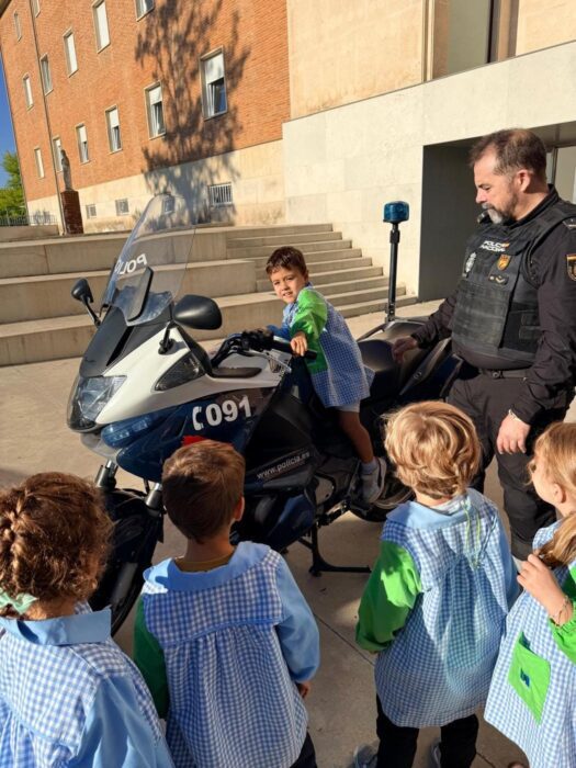 Un niño se sube a una moto de la Policía Nacional junto a un agente y sus compañeros de Infantil.