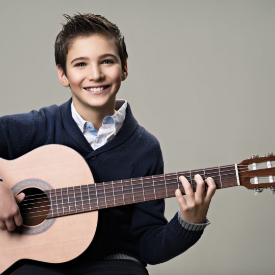 happy-boy-playing-on-acoustic-guitar