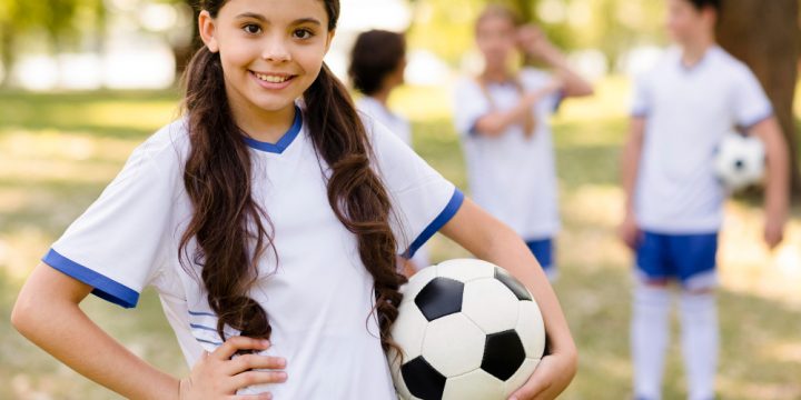 little-girl-posing-with-football-outside